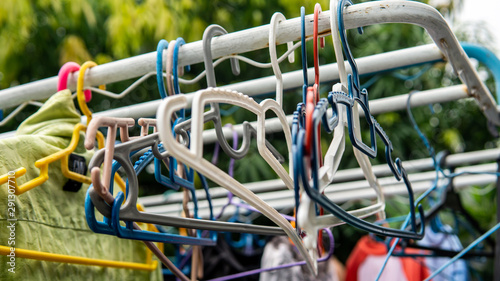 Various color of plastic cloth hangers hanging on the rack.