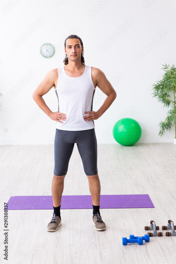 Young handsome man doing sport exercises indoors Young handsome man doing sport exercises indoors