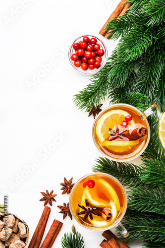 Winter hot tea with lemon  cranberries and spices for Christmas or New Year evening  white background  copy space  top view