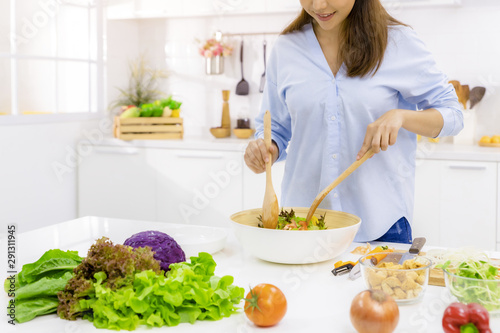 Young Woman Cooking in the kitchen. Healthy Food - Vegetable Salad. Diet. Dieting Concept. Healthy Lifestyle. Cooking At Home. Prepare Food.