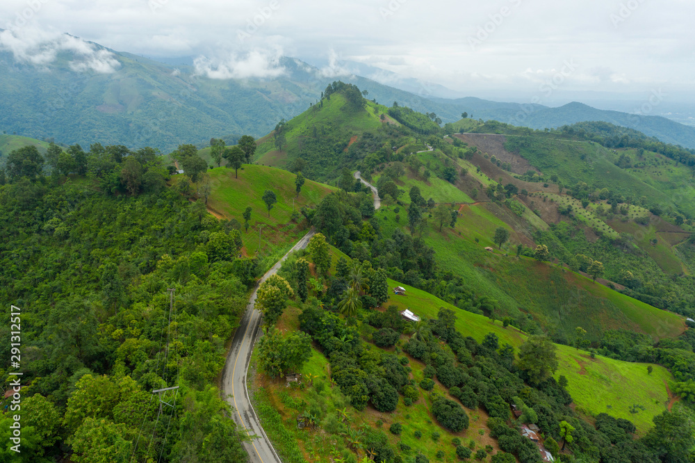 Aerial view of cars driving curves on the mountains and beautiful roads suitable for holiday travel in Nan Province, Thailand.