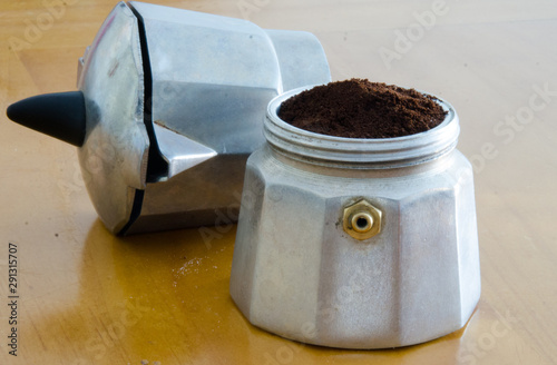 Fototapeta Naklejka Na Ścianę i Meble -  Old coffee maker, making mocha coffee in a typical Italian aluminum coffee mug. The old tradition of making this loved black drink. Milled grains are ready for their work