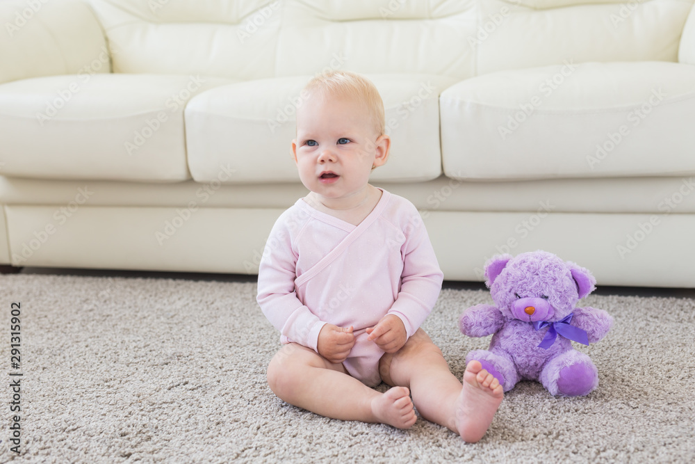 Children and childhood concept - Little baby girl sitting on the floor Children and childhood concept - Little baby girl sitting on the floor
