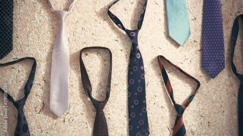 Texture of multi-colored ties hanging on the wall. Accessory businessman. Hours showing 9:30, the start of trading on the exchange.