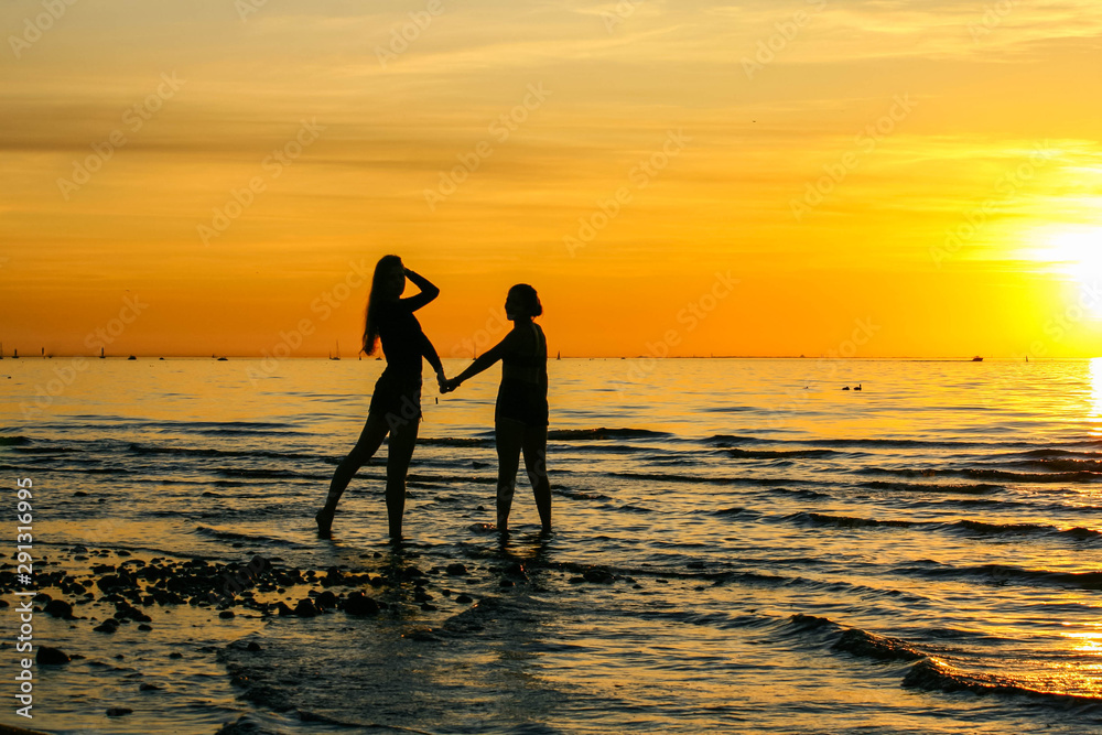 Silhouette of couple on beach at sunset