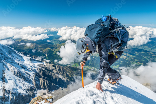Extreme alpinist in high altitude on Aiguille de Bionnassay mountain summit, Mont Blanc massif, Chamonix, Alps, France, Europe
