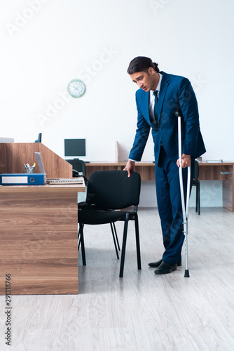 Young leg injured employee in the office
