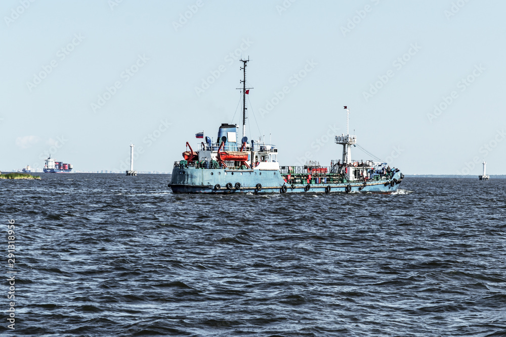 Fototapeta premium A small transport ship goes into the harbor.