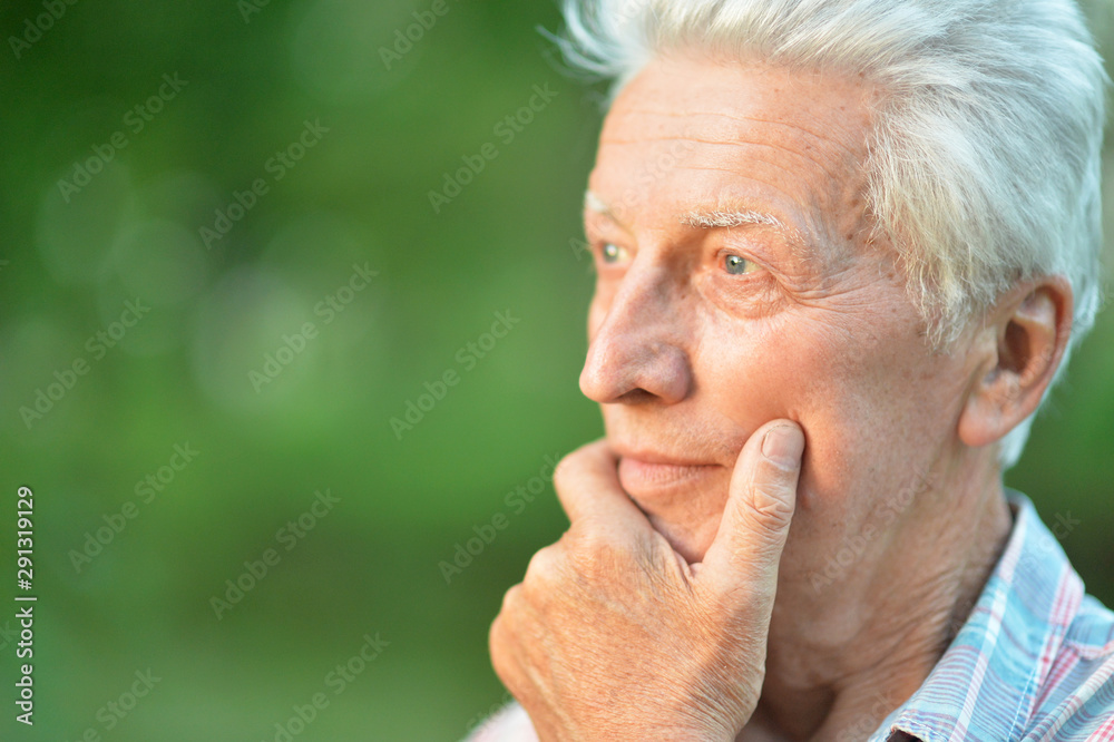 portrait of thinking senior man in park portrait of thinking senior man in park