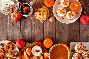 Autumn food double border. Table scene with a selection of pies, appetizers and desserts. Top view over a rustic wood background. Copy space.