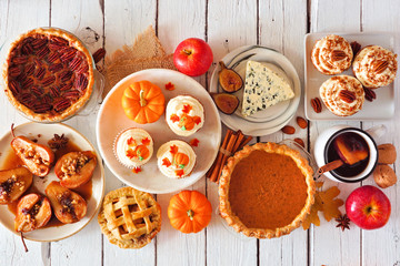 Autumn food concept. Selection of pies, appetizers and desserts. Overhead view table scene over a white wood background.