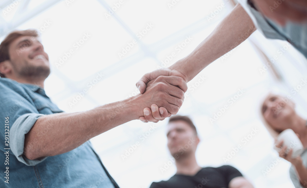 colleagues shaking hands in the office lobby colleagues shaking hands in the office lobby