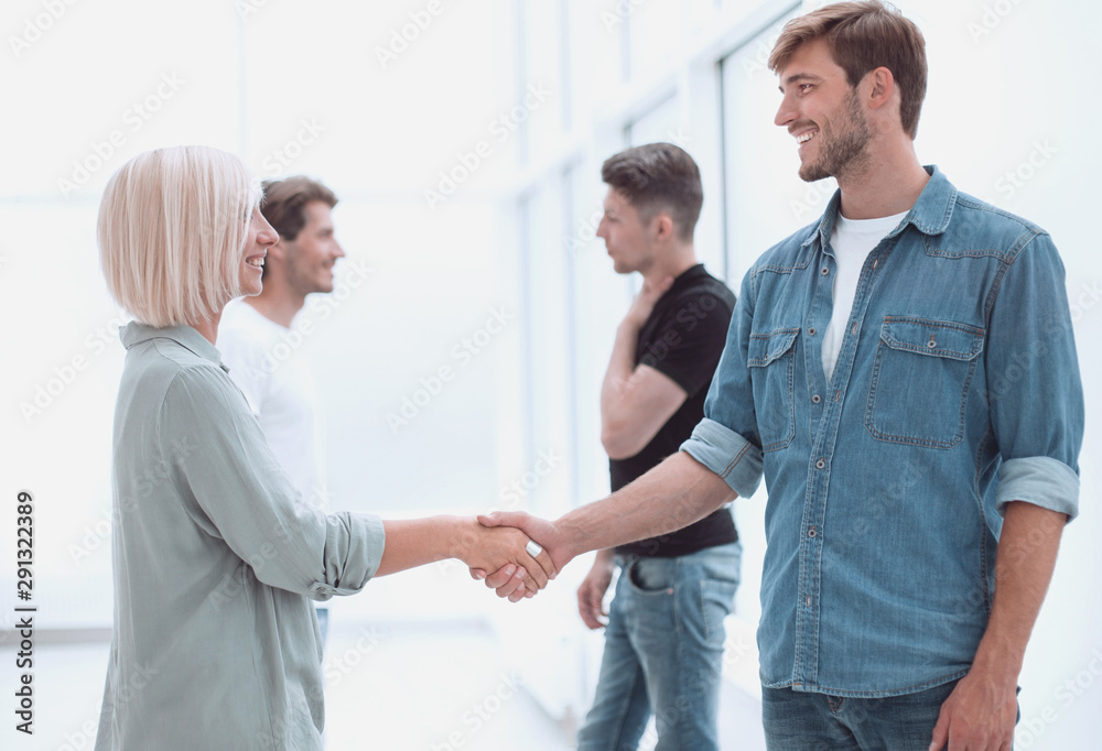 coworkers shaking hands in the office lobby. coworkers shaking hands in the office lobby.