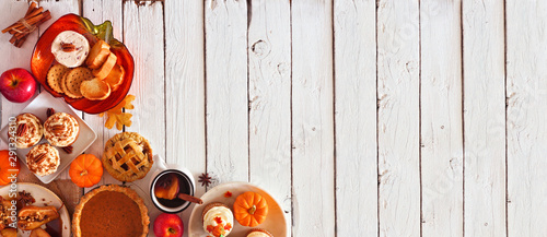 Autumn food corner border banner. Table scene with a selection of pies, appetizers and desserts. Top view over a white wood background. Copy space.
