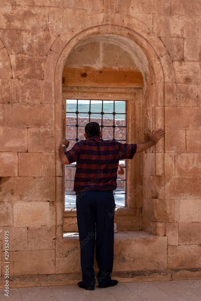 Dogubayazıt, Turkey: a man from behind in front of a window in a courtyard of the Ishak Pasha Palace, semi-ruined palace of Ottoman period (1685-1784), example of surviving historical Turkish palace