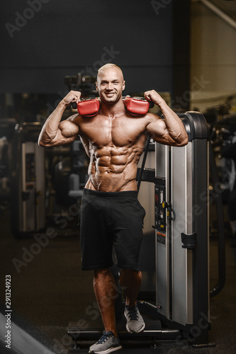Handsome strong athletic man pumping up muscles workout fitness and bodybuilding concept background - muscular bodybuilder fitness men doing arms abs back exercises in gym naked torso.