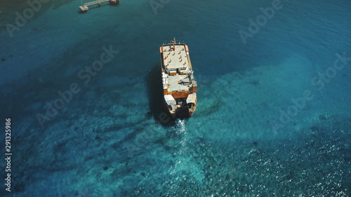 Aerial Top Drone Flight over Big Ferry Boat Sailing to the Island Harbor in Tropical Nusa Penida, Bali Island, Indonesia. Blue Crystal Water. Travel Vacation Tourism © Goinyk