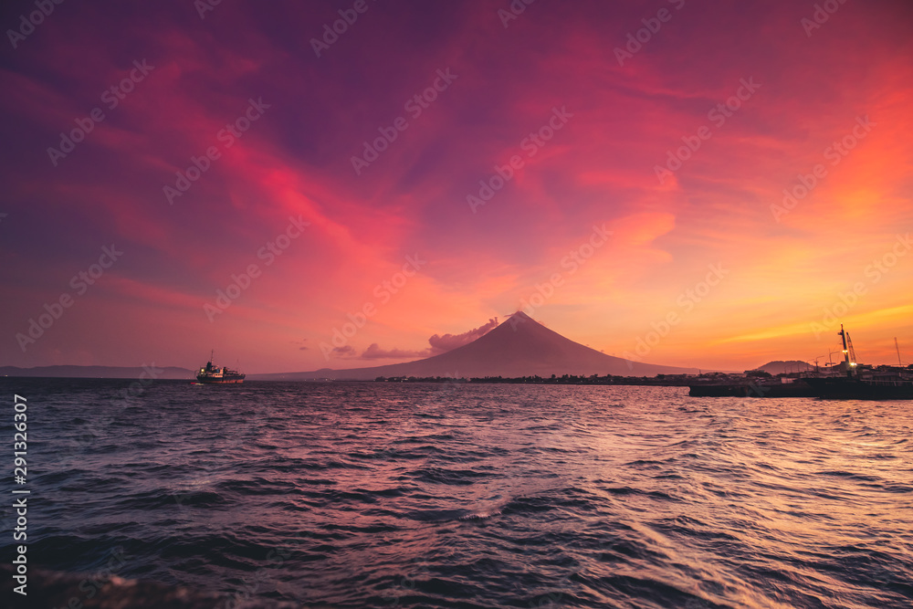 Great Mayon Volcano on Luzon Island Panoramic View. Oriental Mountain Peak and Beautiful Color Sky Sunset. Photography on Ocean with Ship Boat. Philippines Seaside Ecoregion Scenery