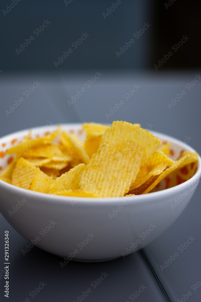 some chips in a bowl on a table some chips in a bowl on a table