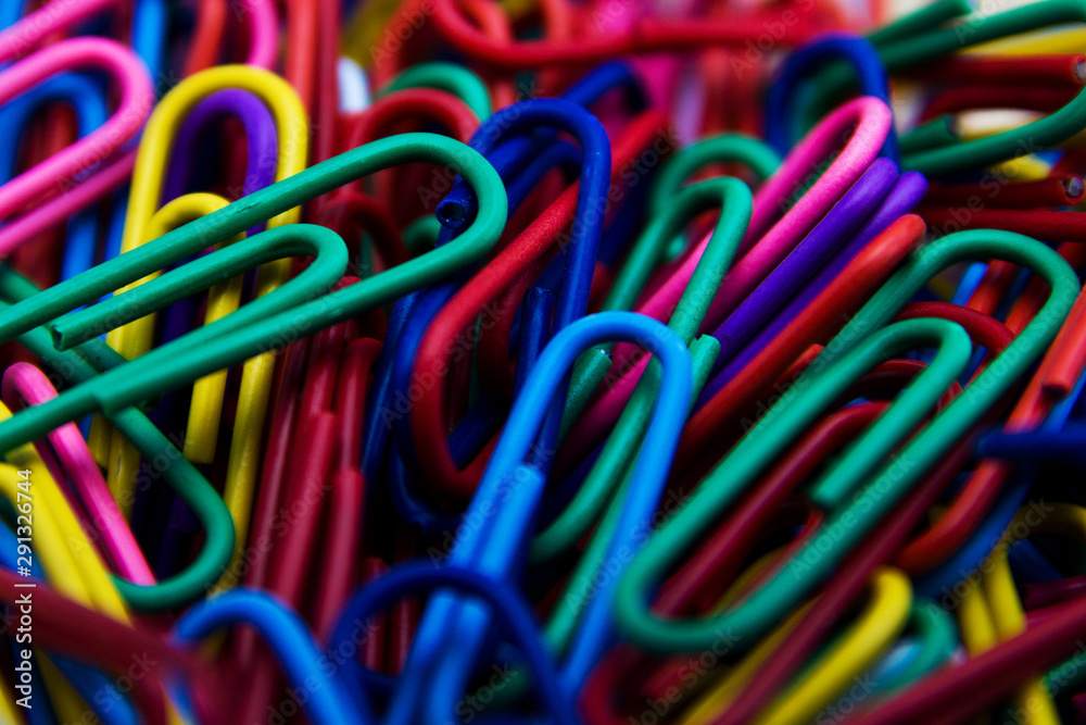 A colorful paper clip background. A variety of scattered colorful plastic paperclips A colorful paper clip background. A variety of scattered colorful plastic paperclips