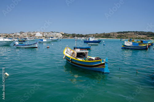 Colorful painted wood boats with the typical protective eyes on a sunny day in Marsaxlokk, Malta. © Marharyta