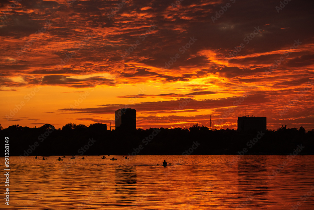 Naklejka premium Bucharest sunset on Herastrau lake with kayak , people having relaxing and fun time