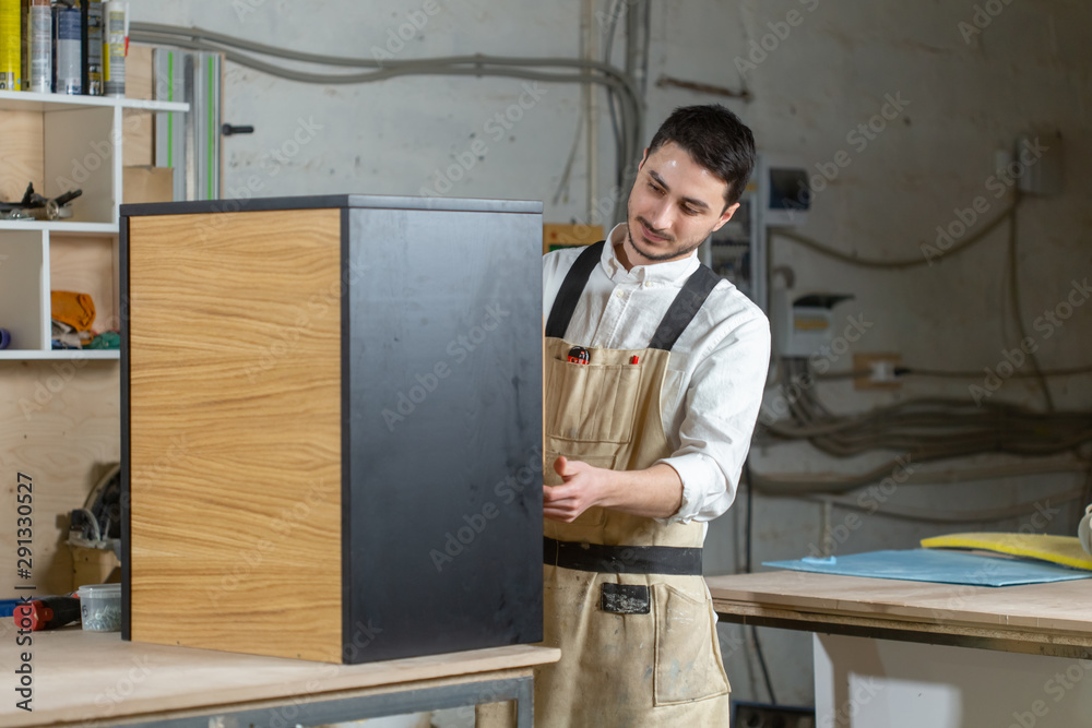Furniture factory and small and medium sized enterprises concept - Man collects furniture details Furniture factory and small and medium sized enterprises concept - Man collects furniture details