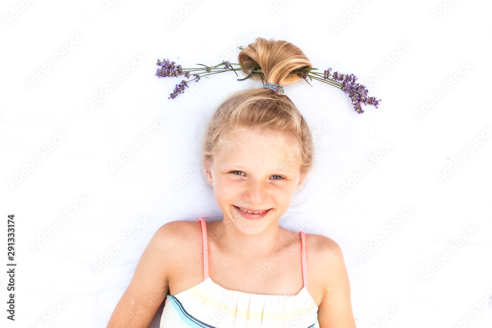 cute smiling little child with funny blond bun haircut with lavender flower copy space cute smiling little child with funny blond bun haircut with lavender flower copy space
