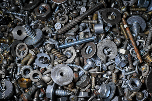 Abstract background with various screws, nuts, bolts and washers and other fasteners. Macro.