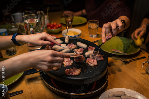 Homemade fondue dinner with cheese and sausages