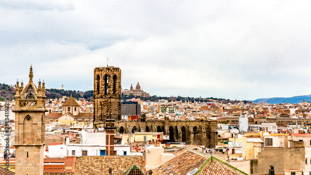 Cityscape of roofs of houses with tiles and the bell towers of old churches, wonderful cloudy day with a sky covered with thick clouds in Barcelona, ​​Spain