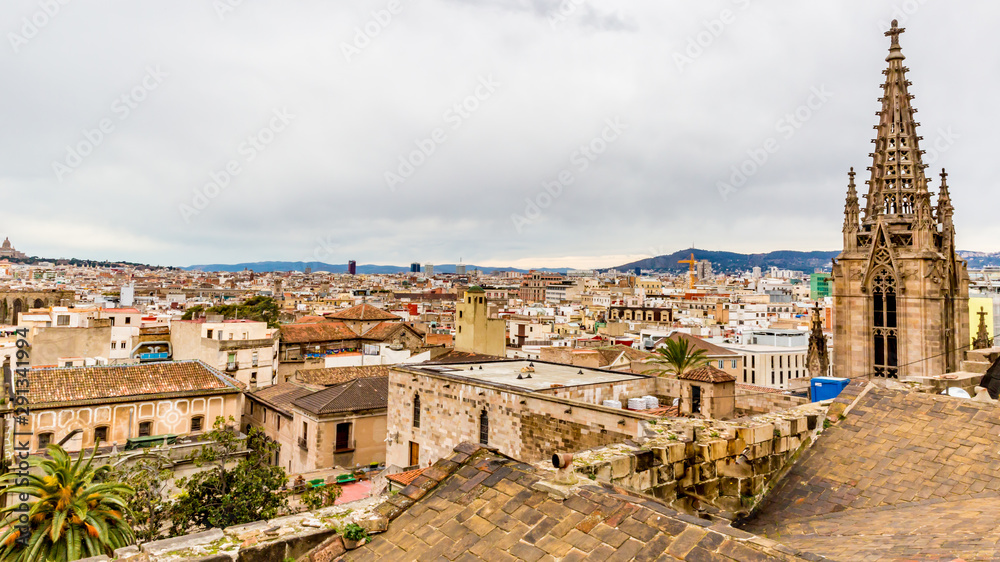 Aerial view of roofs of houses  and the bell towers of an old church in  Barcelona, ​Spain