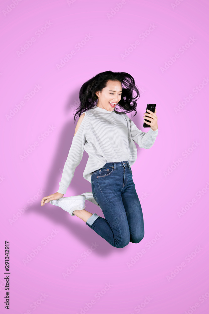 Young woman using phone with happy expression Young woman using phone with happy expression