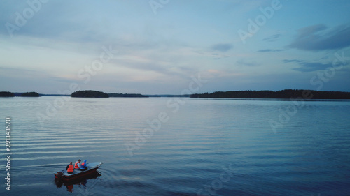 Photography aerial view of a boat in the middle of lake Saimaa at sunset
