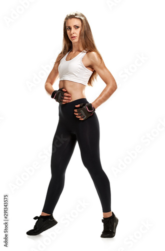 Full portrait of fit athletic young woman posing in sportswear