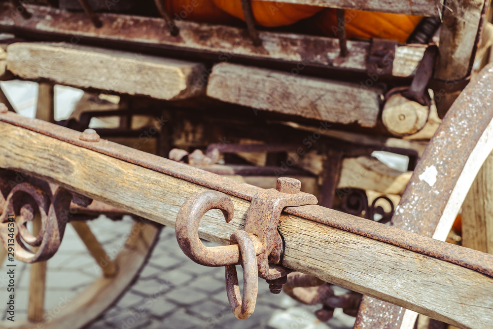 old carriage with rusty wheels and pumpkins