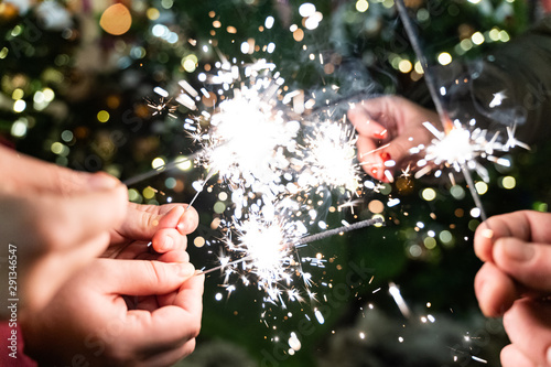 Group of friends burning Bengal lights during winter time celebrations, Christmas, New Year's Eve.