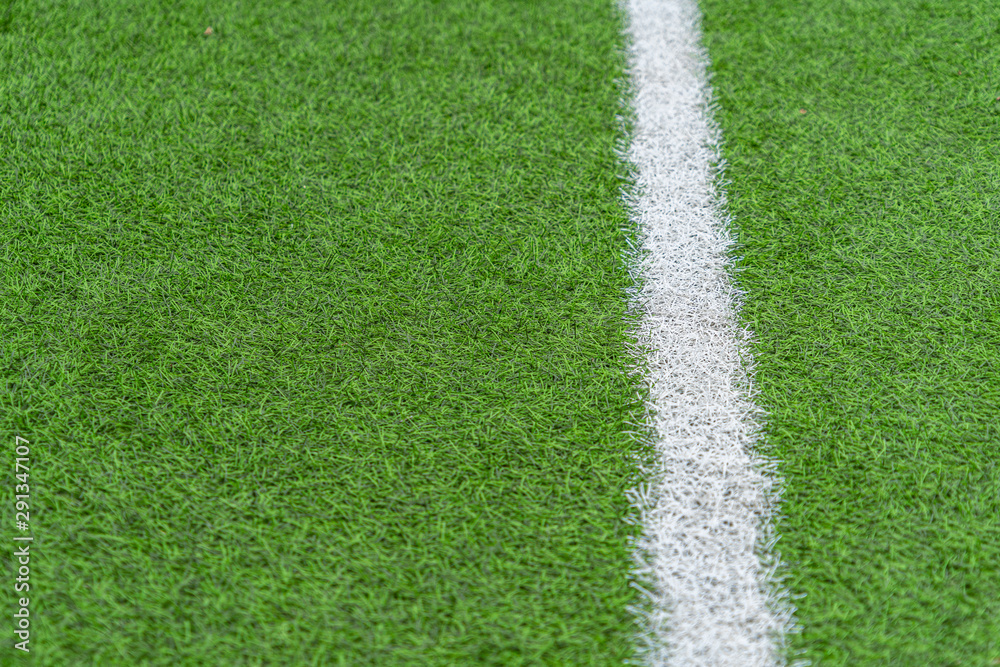 Green artificial grass soccer sports field with white stripe line Green artificial grass soccer sports field with white stripe line