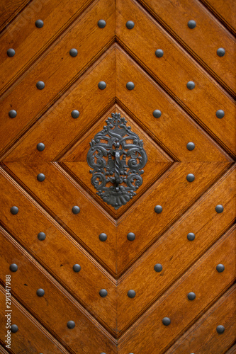 The wooden surface is fancifully decorated with a forged pattern and steel rivets
