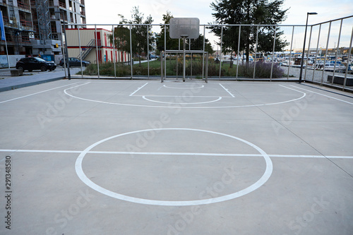 White marking on playing concrete or asphalt surface on outdoor basketball court at school or college with no people around. City, urban environment, recreation, activity, competition and youth