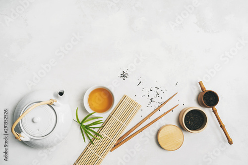 Asian food concept with Tea set, chopsticks, bamboo mat, on white background for your own design. .