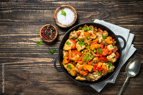 Chicken Stir fry with vegetables on wooden table.