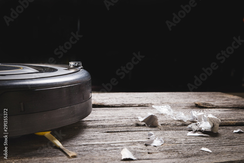 Robot vacuum cleaner on laminate wood floor, Smart robotic automate wireless cleaning technology machine in living room.