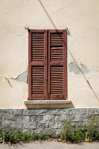 old window with shutters, window closed, building with cracked facade, old wall