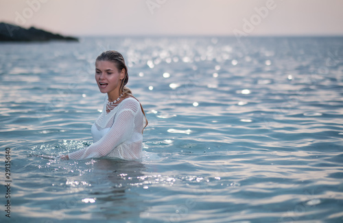 Young beautiful woman standing in the water.