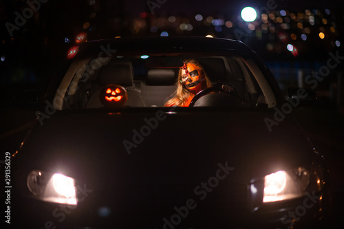 Young blonde girl with halloween face art posing outdoor.  Helloween celebration concept.