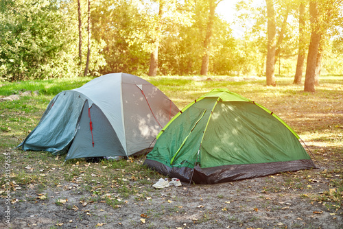 Two camping touristic tents in a morning forest