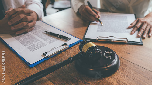 Judge gavel with Justice lawyers deciding, consultation on marriage divorce between married couple and signing divorce documents on table. Concepts of Law and Legal sevices.