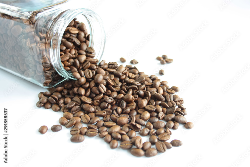 Coffee beans spilling out of the jar, white background