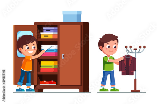 Smiling preschool boys kids taking clothes out of closet shelf and hanging suit jacket on floor hanger stand